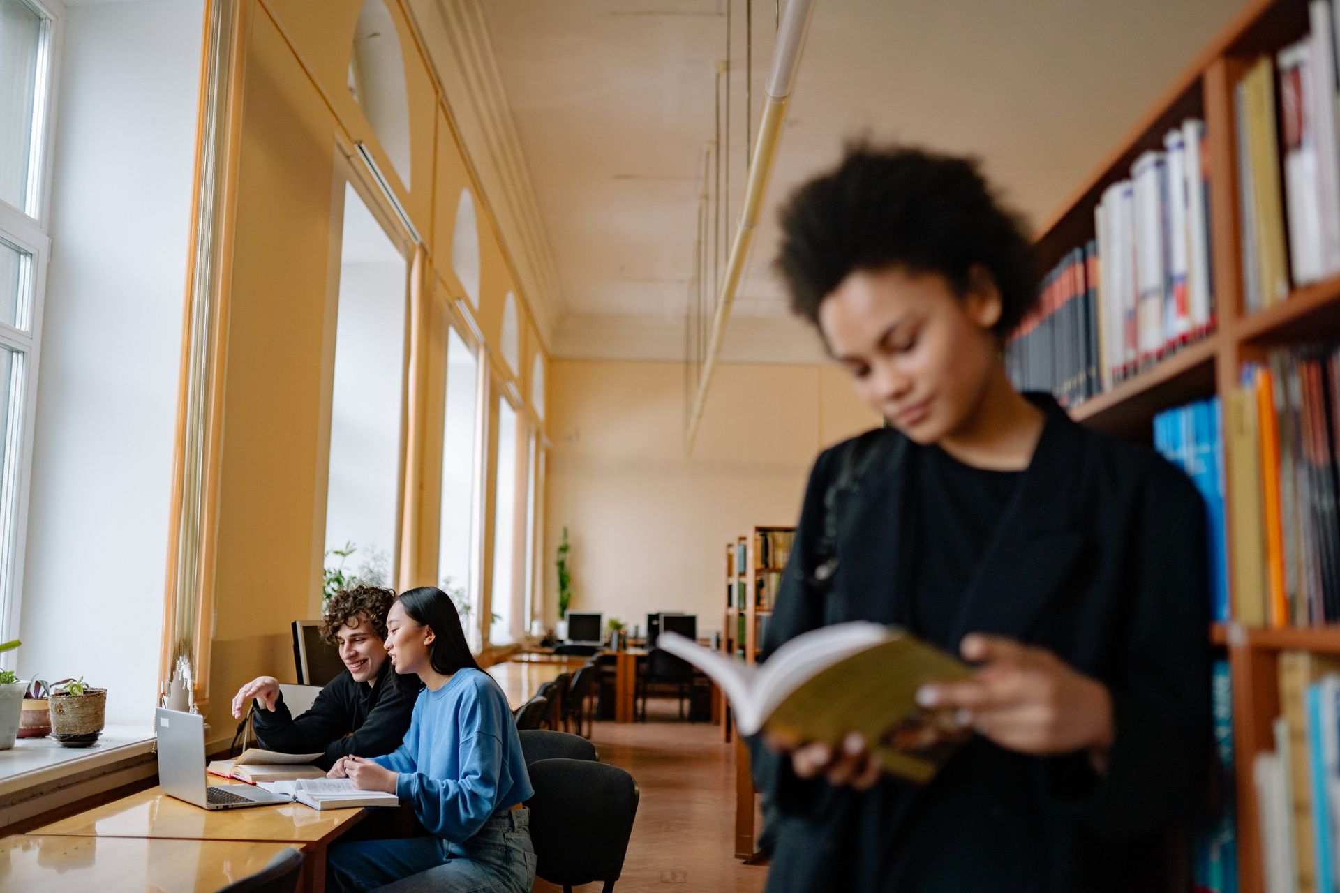 Estudiantes consultando libros en una biblioteca
