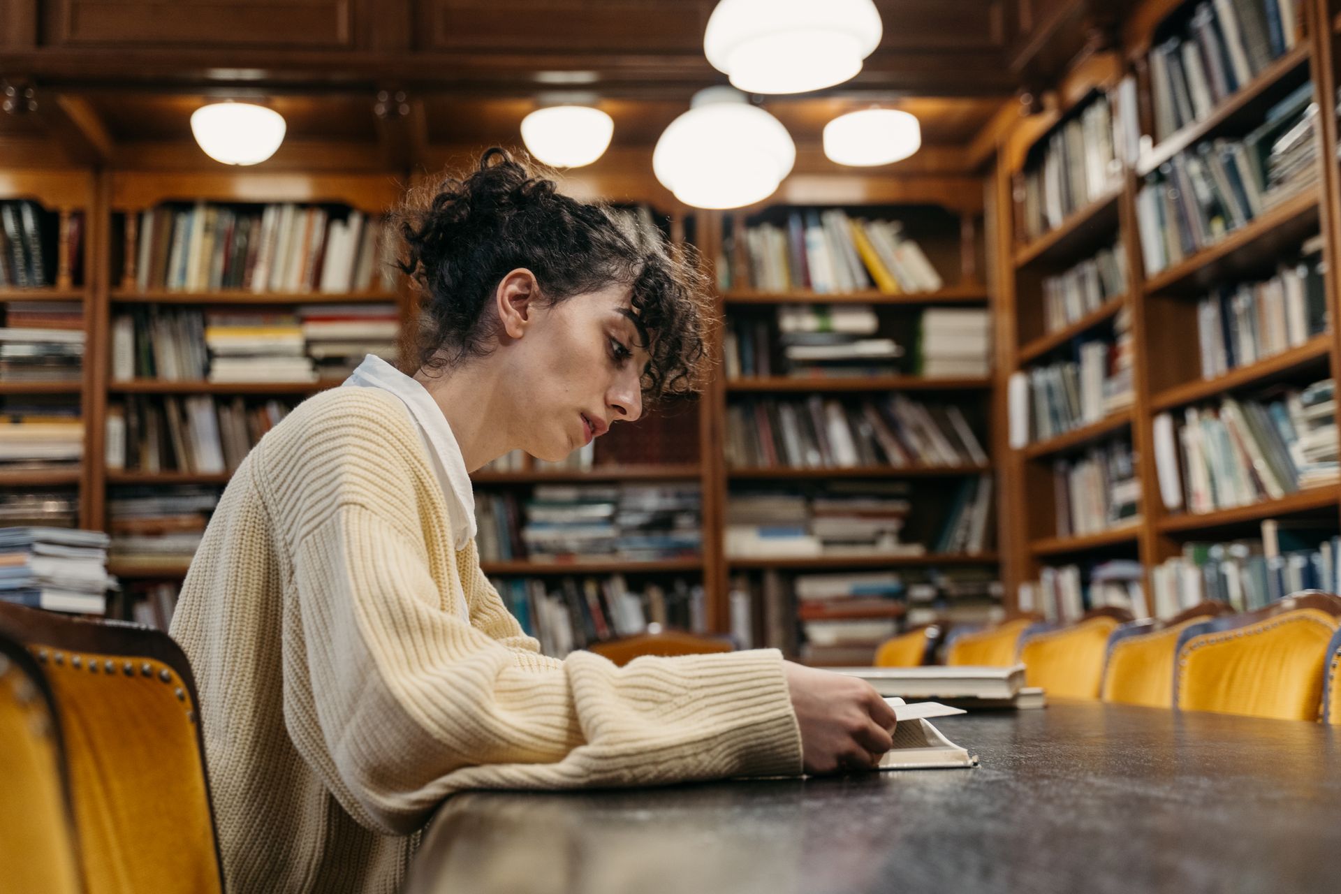 Estudiante trabajando en una mesa de biblioteca
